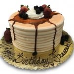 Pancake shaped birthday cake topped with fresh fruit