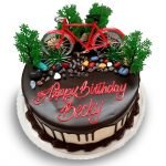 Birthday cake with a toy bicycle and chocolate rocks