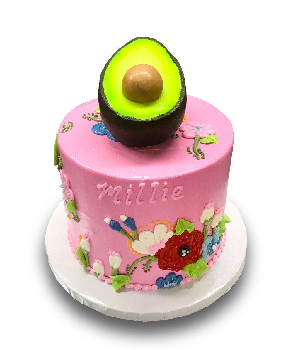 Drawn buttercream flowers and fondant avocado on a pink buttercream cake