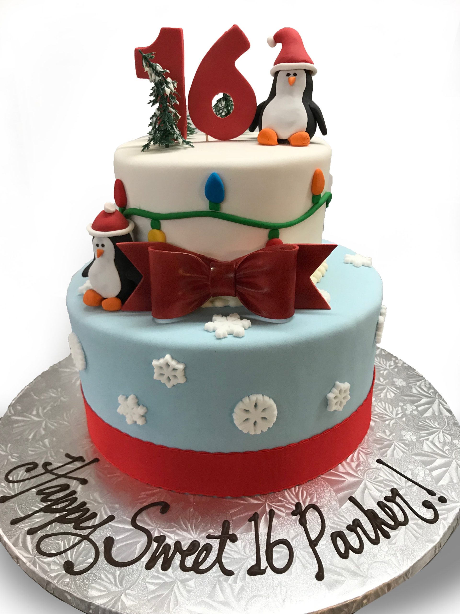 Fondant covered two tier birthday cake with fondant penguins and lights and sugar snowflakes