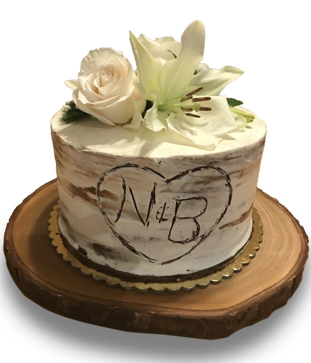 Carved birch stump buttercream cake with fresh flowers